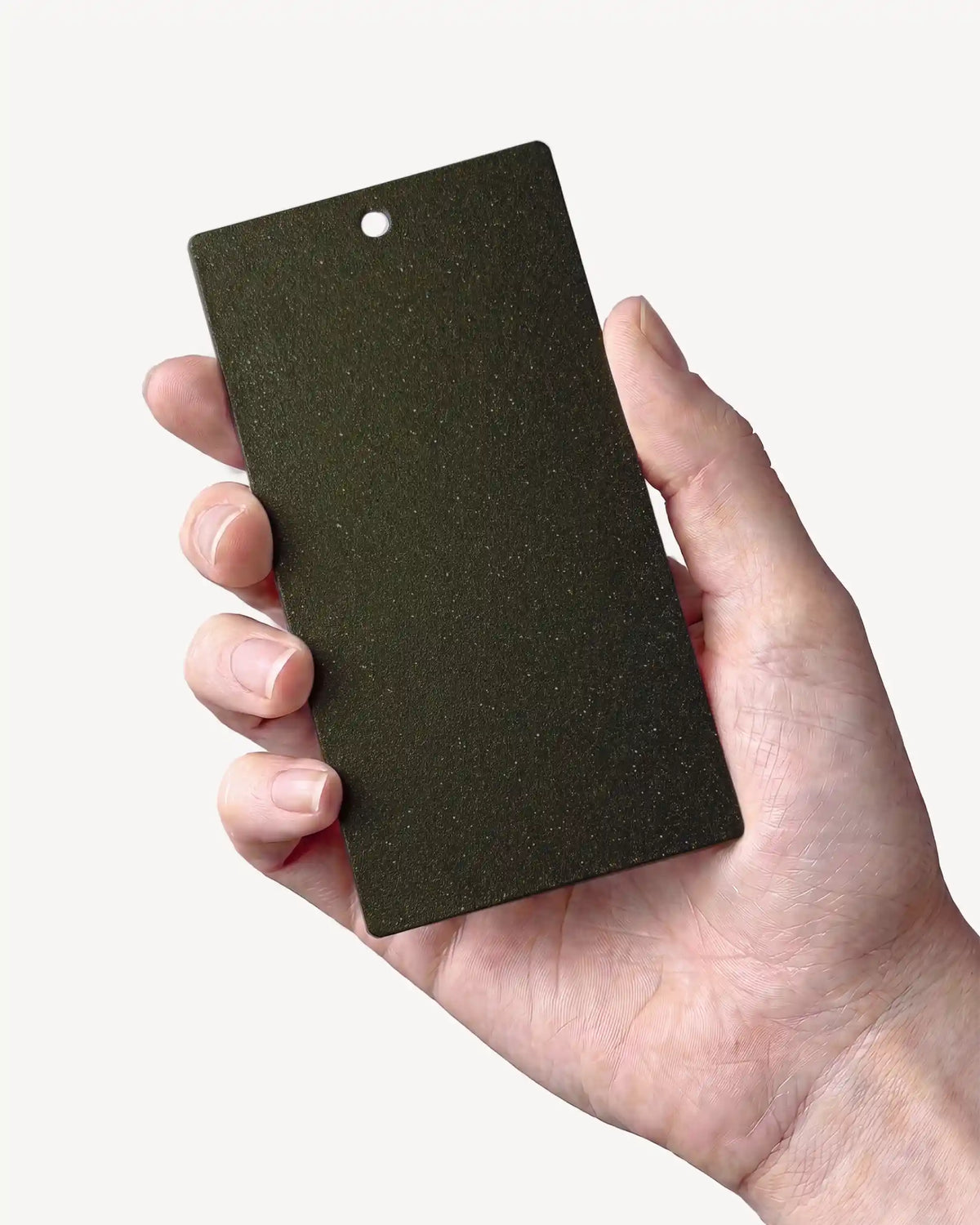 Hand, das ein Muster in der Farbe Olivgrün PILOTIS hält