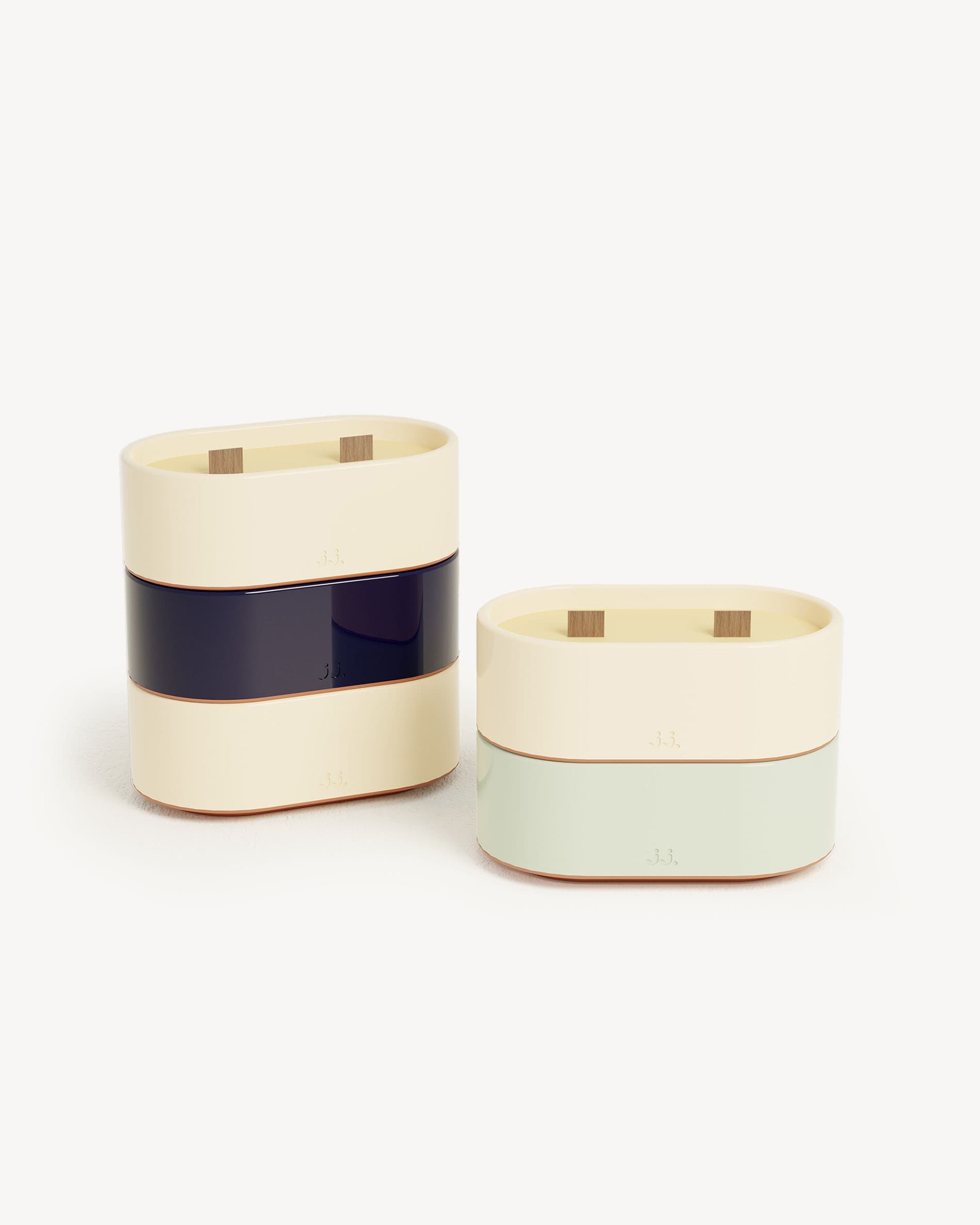 Totem-Kerze S aus zweifarbiger Keramik in Beige-Ivory und Marineblau, mit Zitronengrasduft und Noten von Zitrone und Meersalz, präsentiert neben einer Variante in Wassergrün mit Eukalyptus.