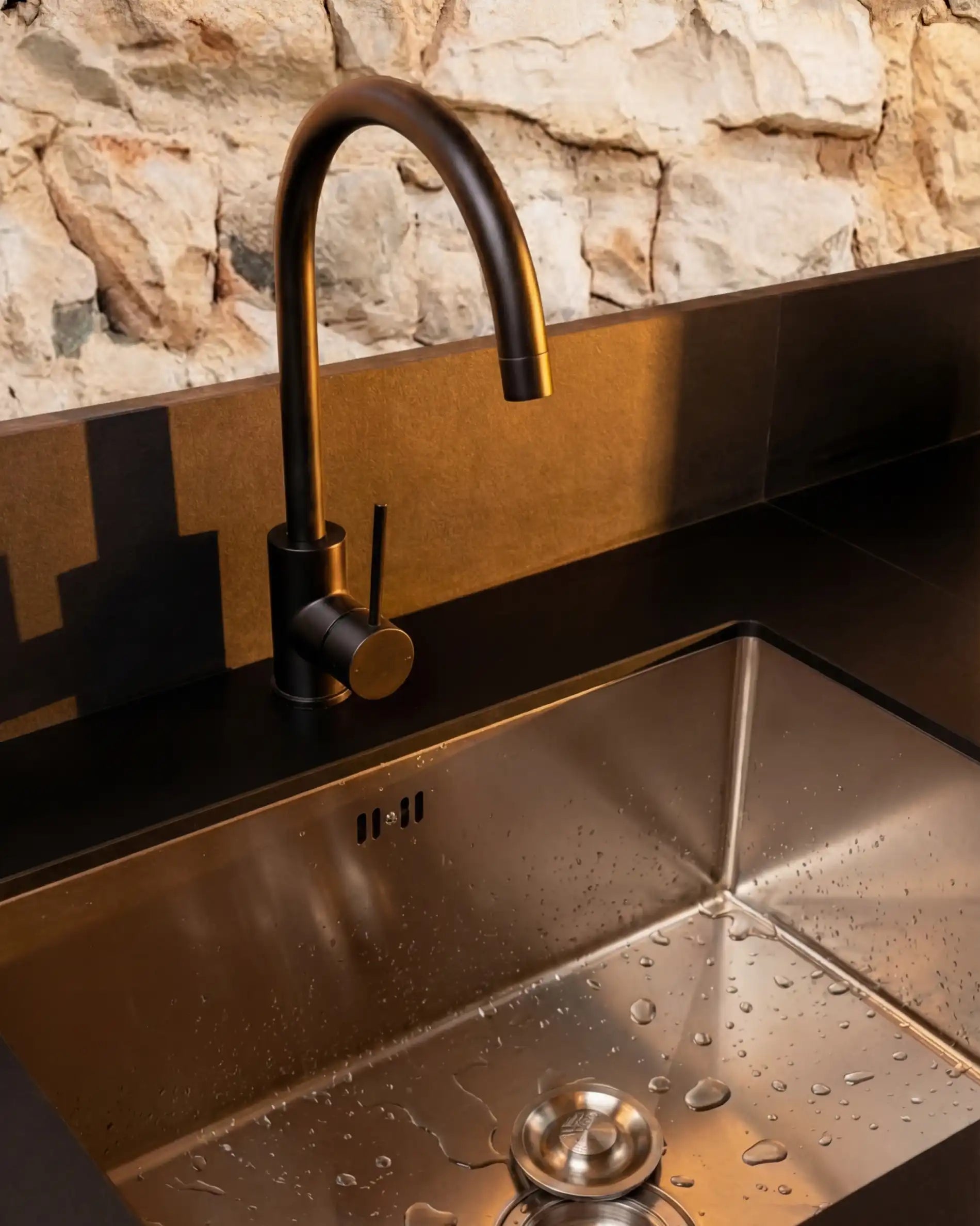 Detailansicht: Edelstahlspüle mit schwarzem Wasserhahn auf Kokko Outdoor-Küche