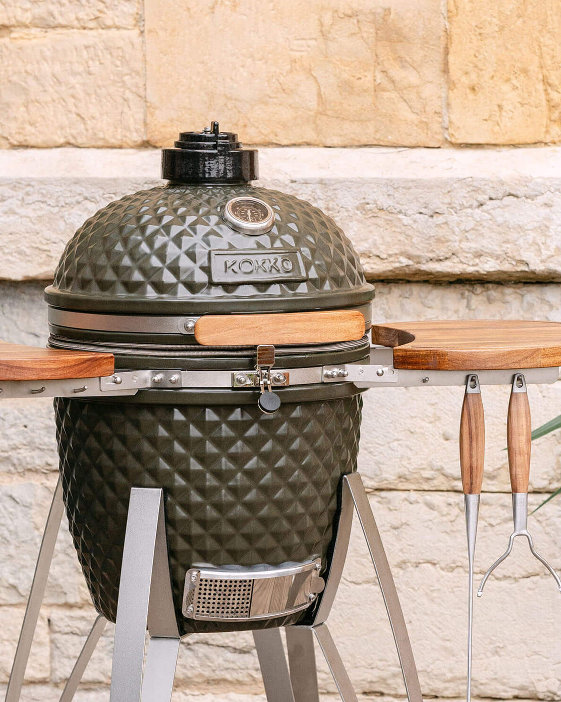Barbecue kamado Kokko 18 pouces coloris vert olive, présenté seul en extérieur.