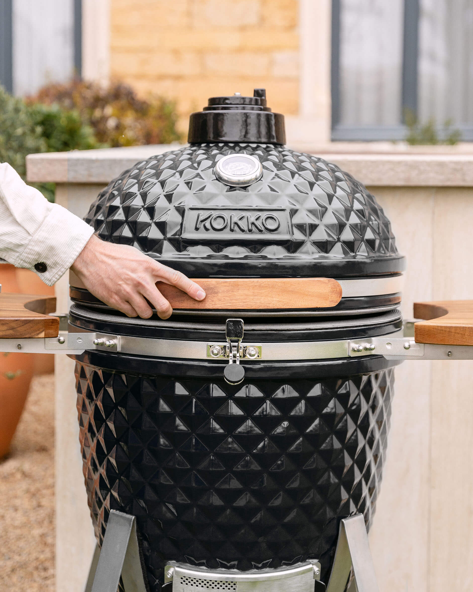 Kamado Kokko XL 22 pouces en céramique noire installé en extérieur.