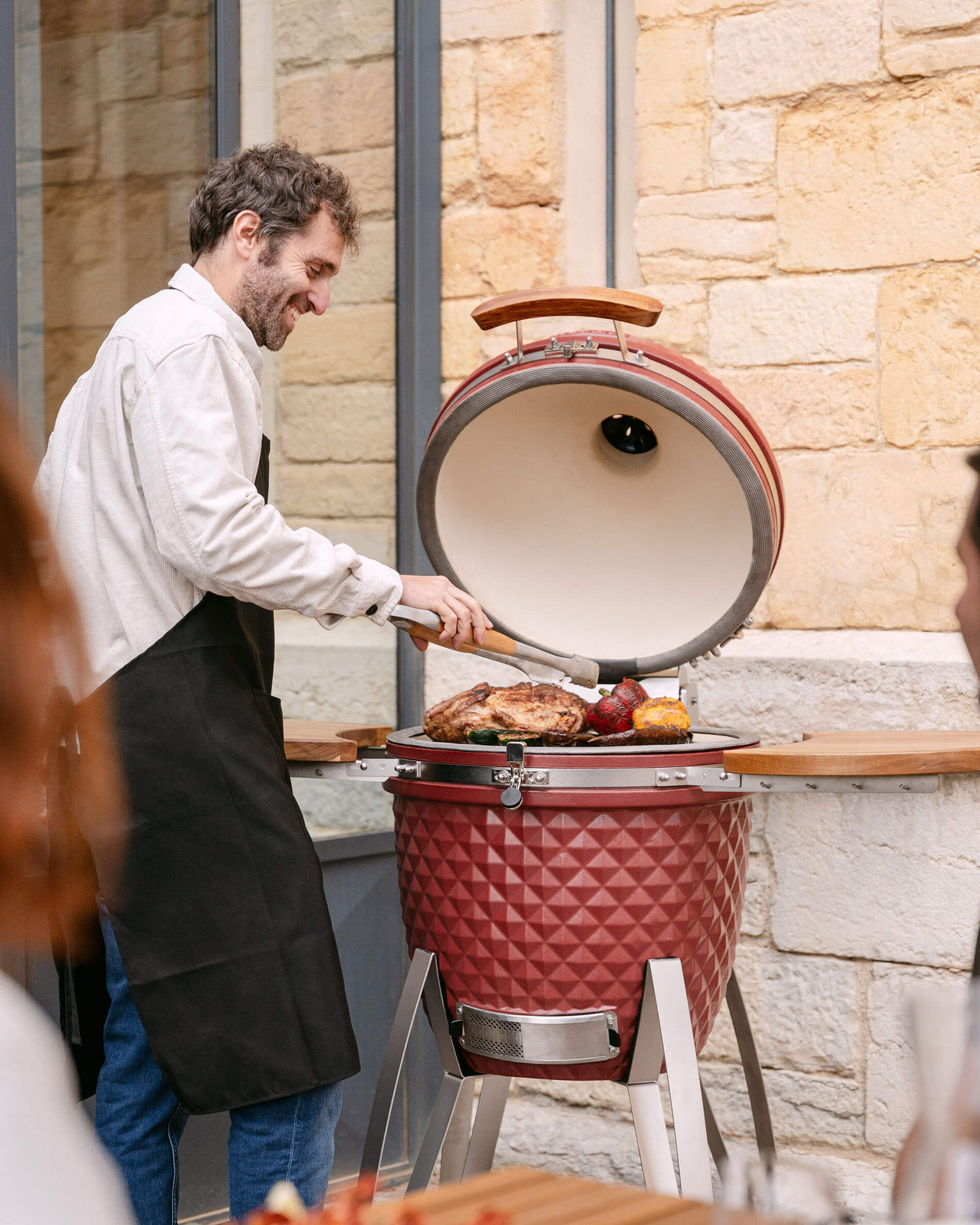 Kamado Kokko pouces en céramique rouge oxyde utilisé en situation de cuisson.