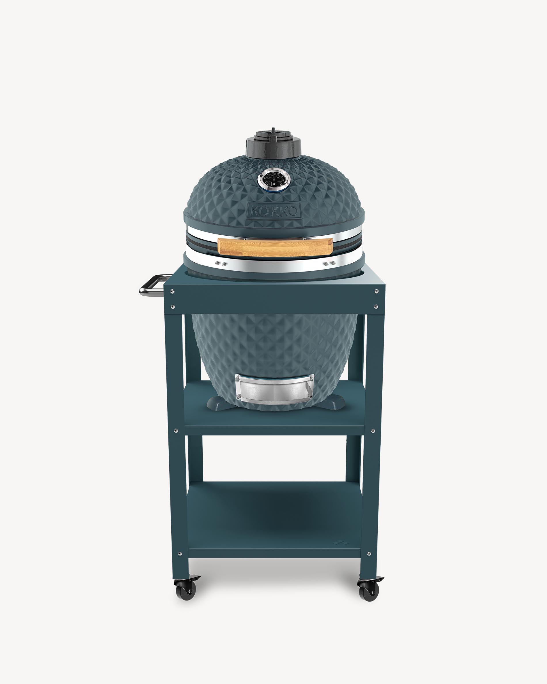 Barbecue kamado Kokko L 18 pouces coloris ocean, installé sur desserte avec rangements et roulettes.
