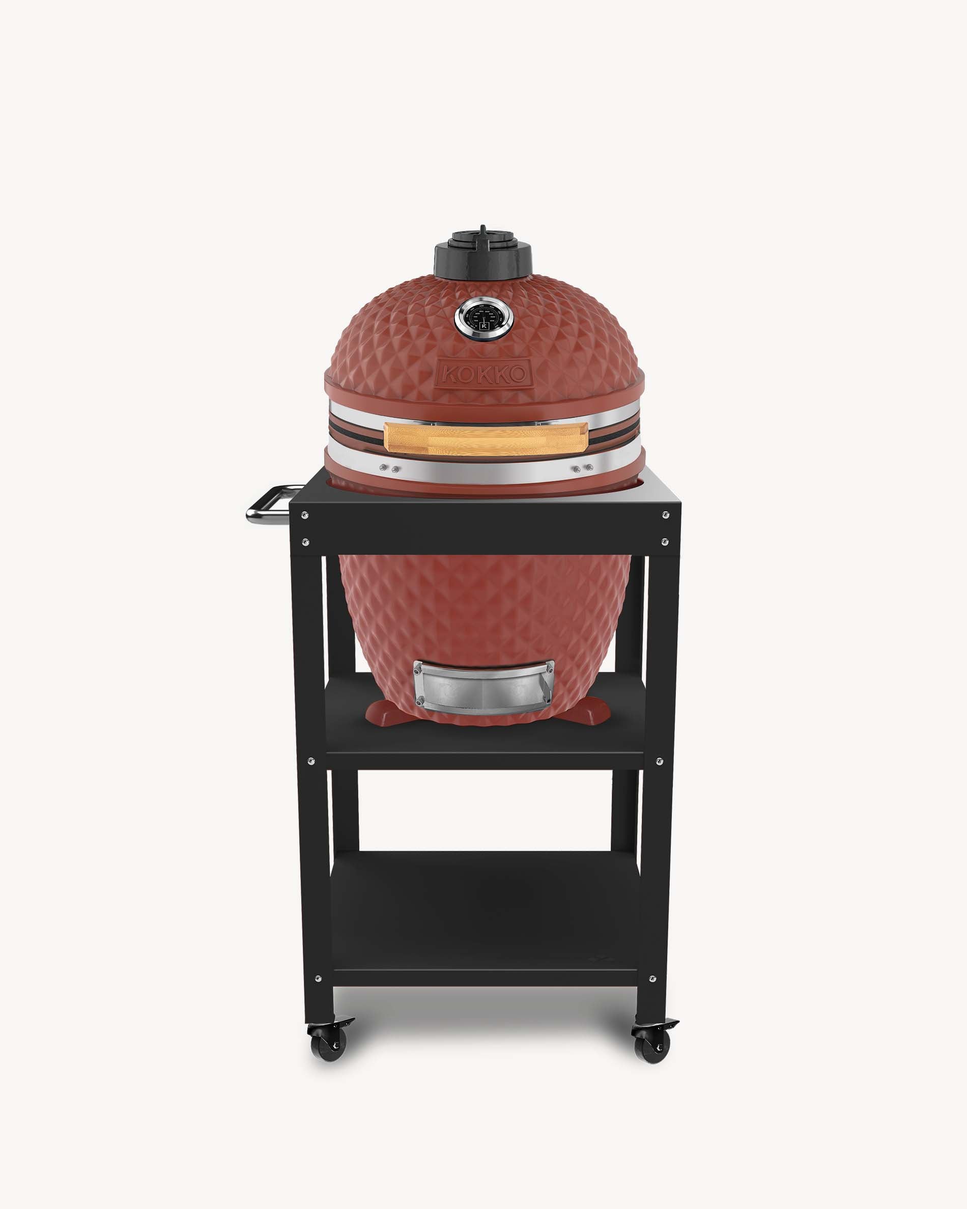 Barbecue kamado Kokko L 18 pouces coloris oxyde, installé sur desserte avec rangements et roulettes.