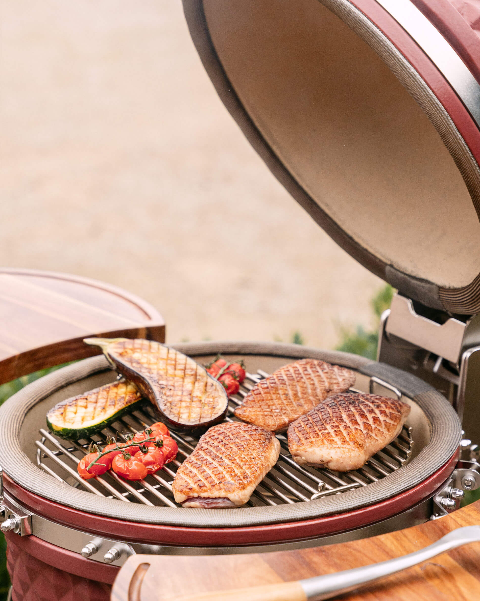 Kamado Kokko L 18 pouces en cours de cuisson avec viandes et légumes sur la grille.