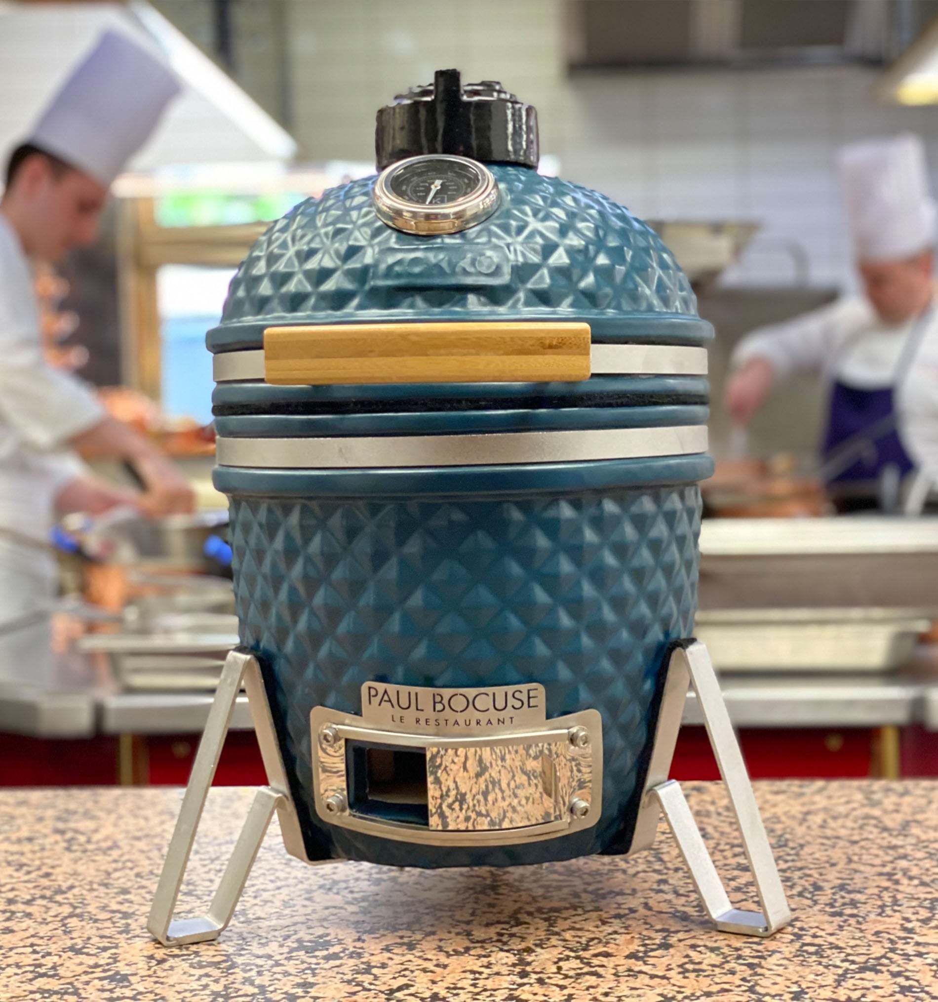 Kamado Kokko in Ozeanblau vor einem Gourmetrestaurant von Paul Bocuse.