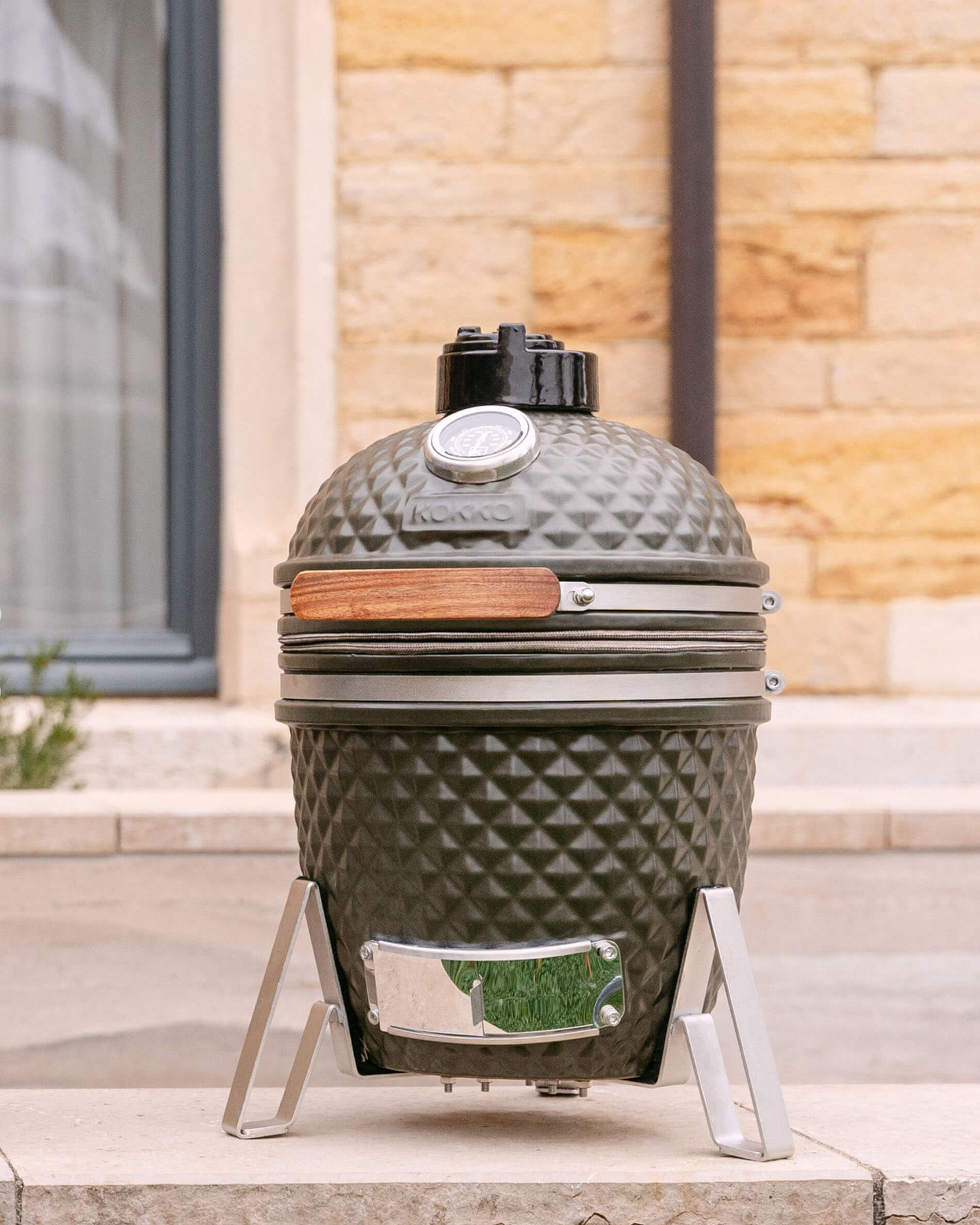 Kamado Little Kokko 13 en céramique vert olive sur son support.