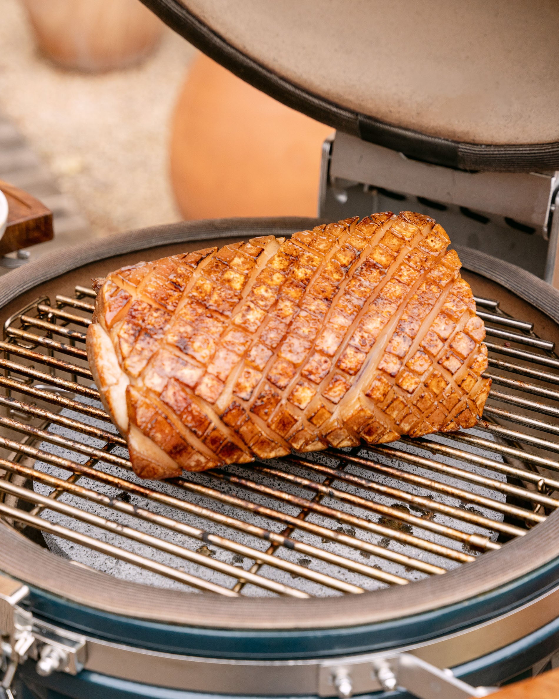 Schweinebraten auf dem Grillrost eines Kokko Kamado, Deckel offen, mit goldbrauner, gleichmäßiger Kruste.