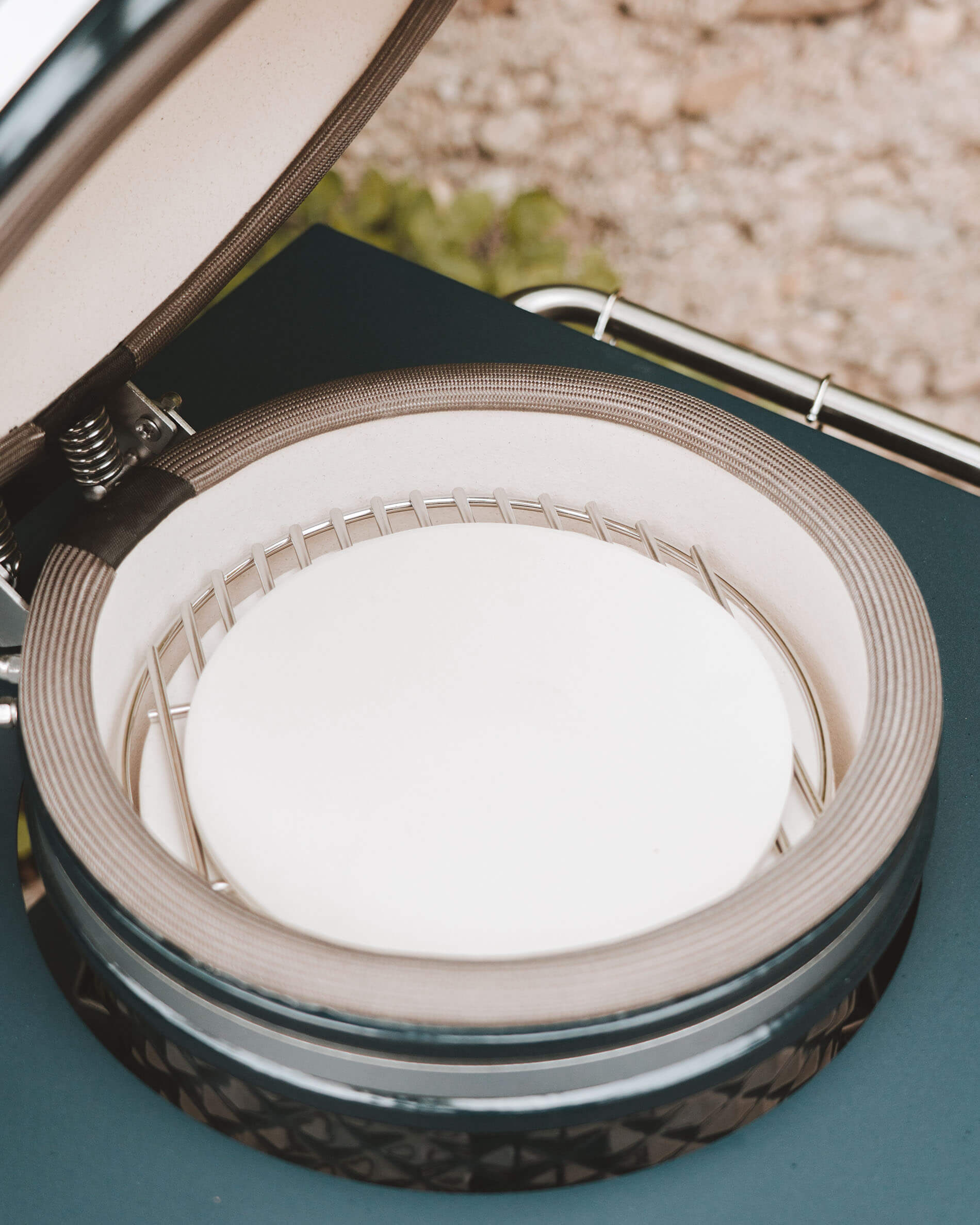 Innenansicht des Kokko Kamado mit eingesetztem Pizzastein auf dem Grillrost, Detailansicht der Keramik und der Dichtung.