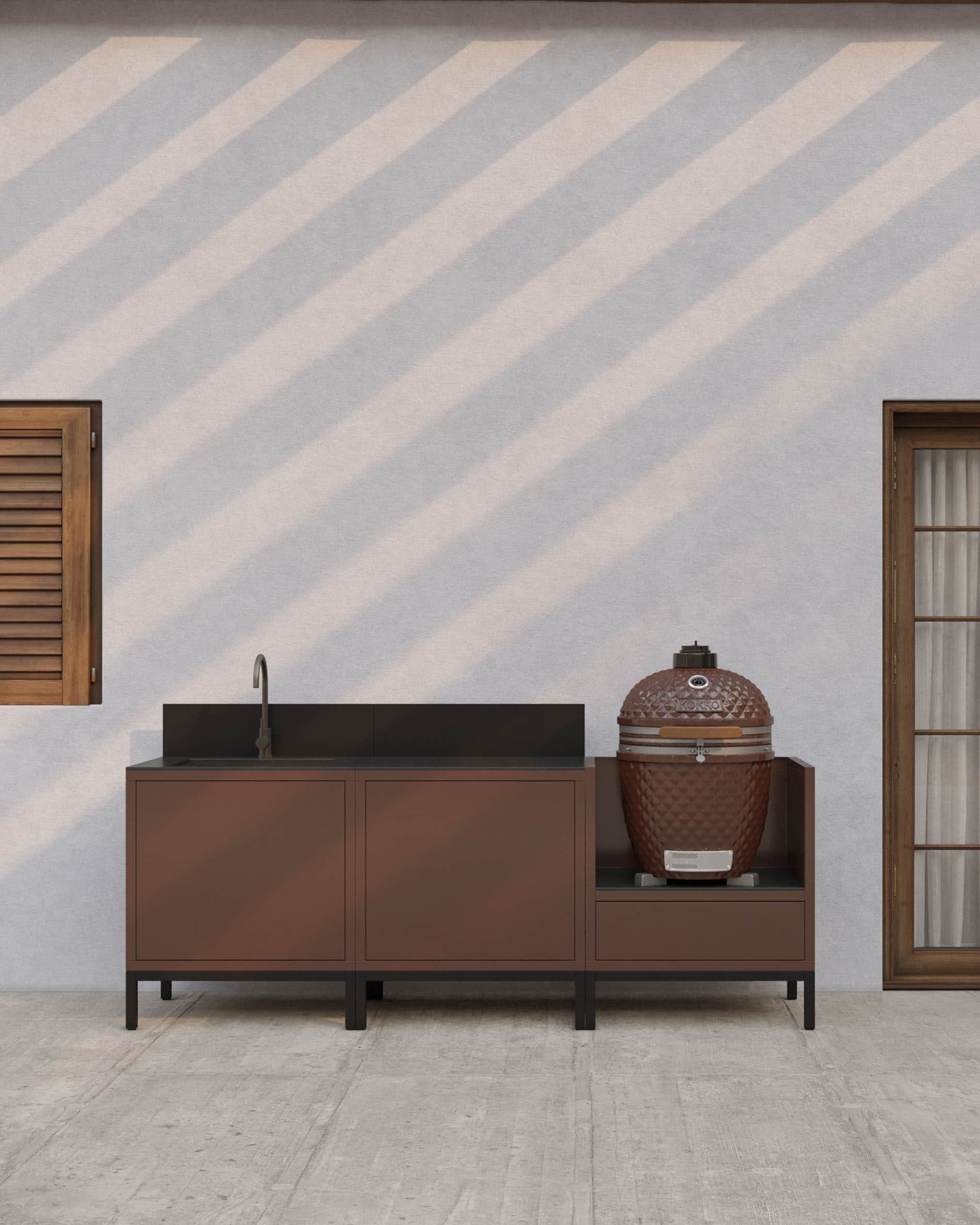 Cuisine pilotis en finition rouille avec évier intégré, plan de travail sombre, crédence assortie et module kamado dédié sur structure surélevée.