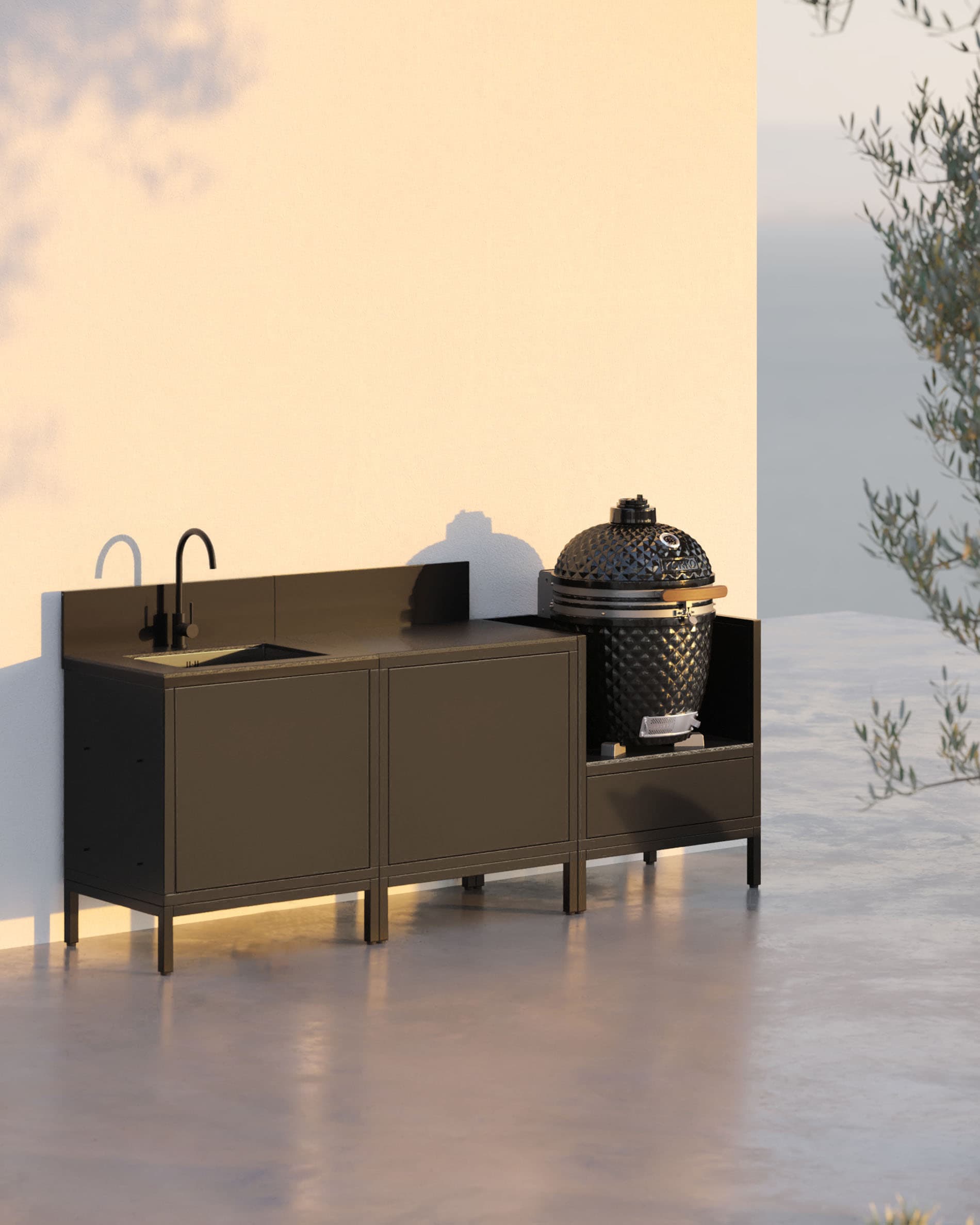 Cuisine pilotis 3 modules avec évier et kamado, meuble noir avec une porte de rangement ouverte et plan de travail sombre.