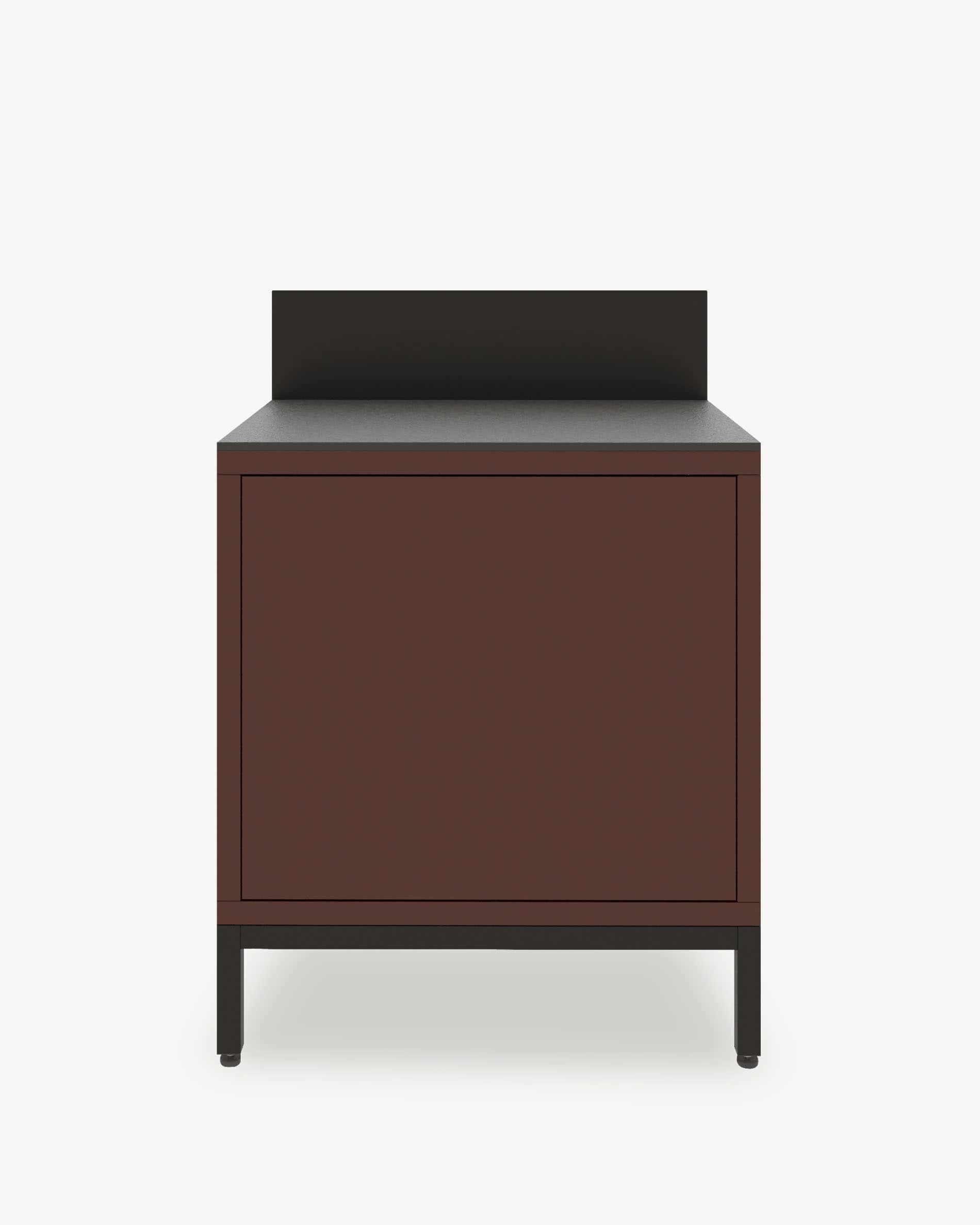 Module de cuisine pilotis avec rangement fermé, façade coloris brun rouille, plan de travail sombre et crédence intégrée.