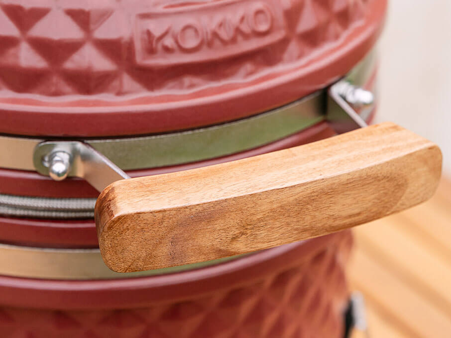 Poignée en bois d’acacia du Little Kokko, montée sur le couvercle en céramique pour une prise en main isolante.