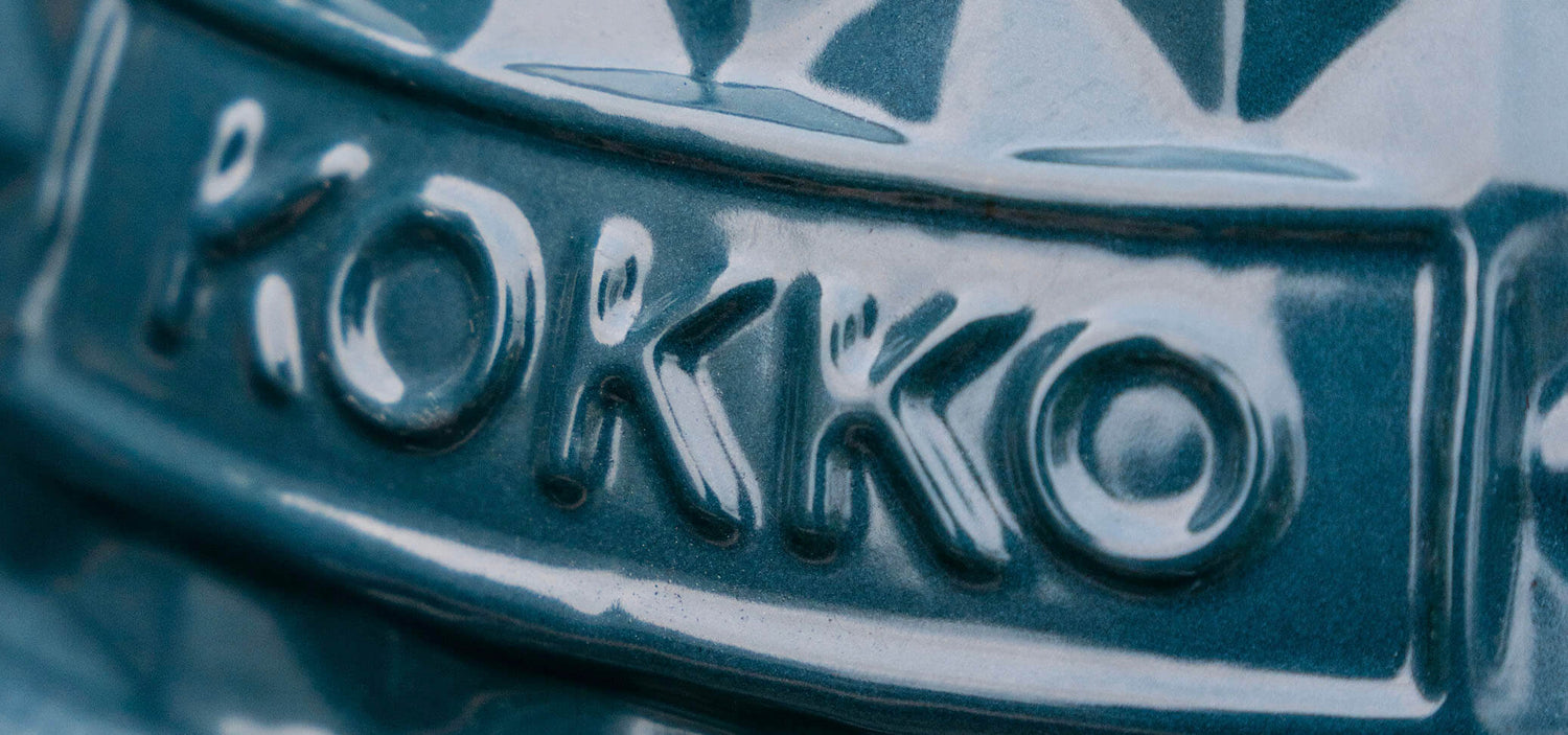 Gros plan sur le logo Kokko embossé dans la céramique émaillée vert canard du kamado.